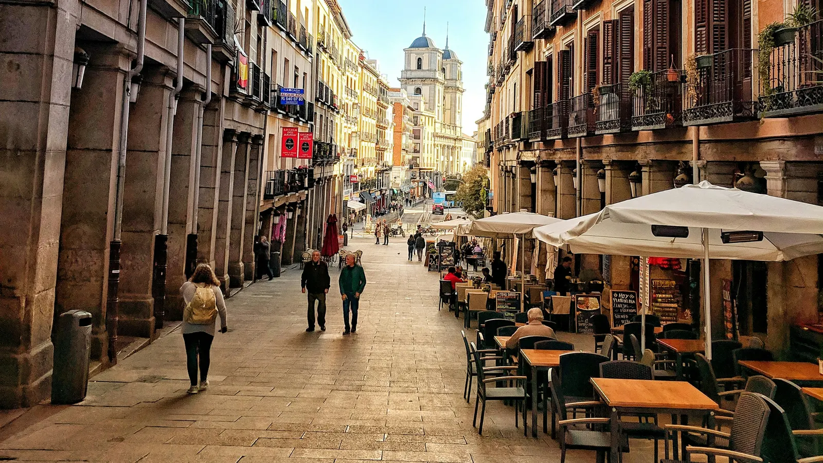 Calle peatonal de Madrid con terrazas llenas y gente paseando